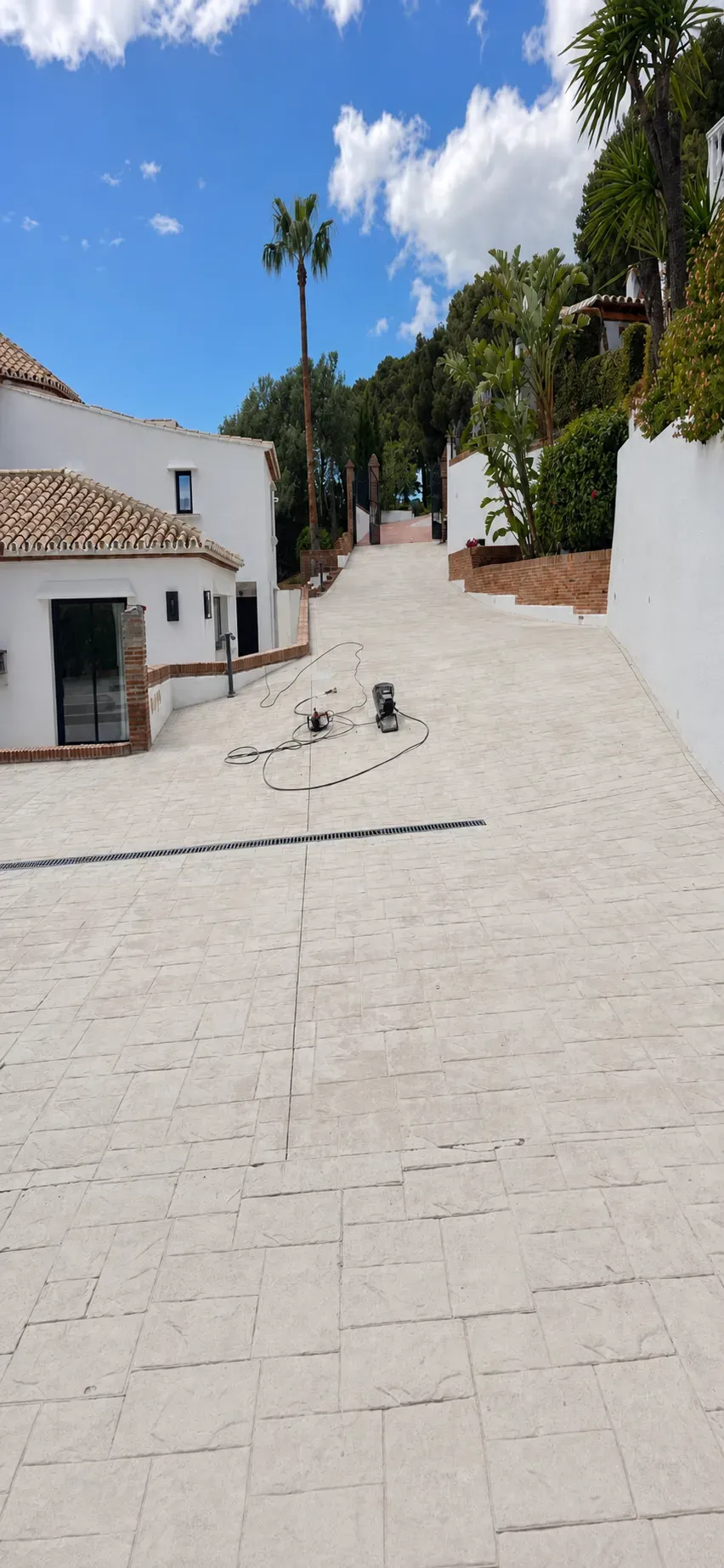Driveway after: new cream paving between the same white walls
