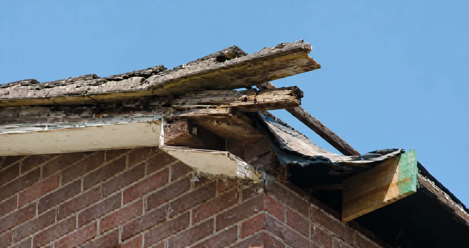 Roof corner with rotten fascia and broken timber exposed
