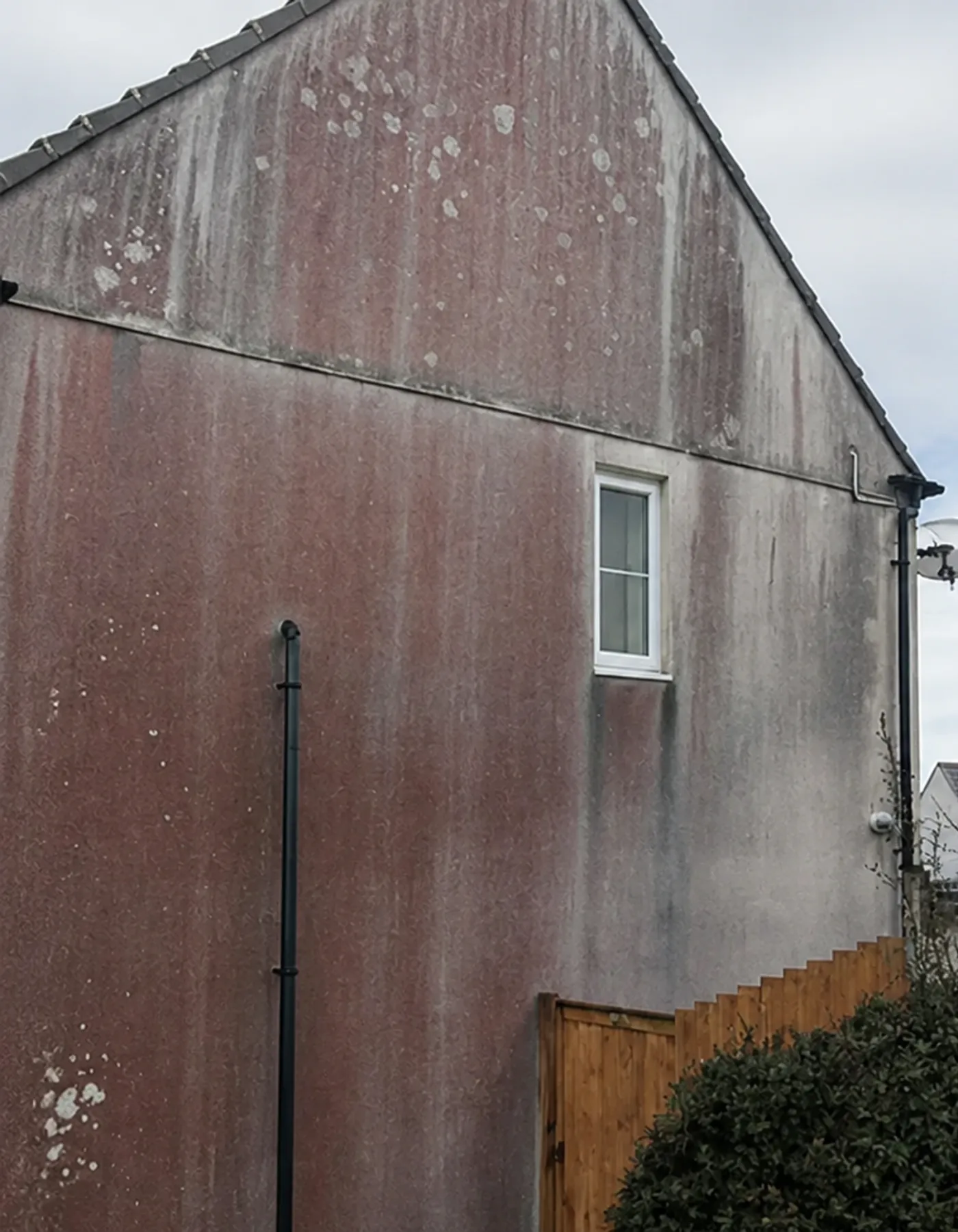 Gable wall with heavy rust and algae staining
